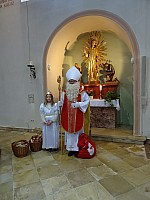 Der Hl. Nikolaus und das Engelchen beschenken die Kinder